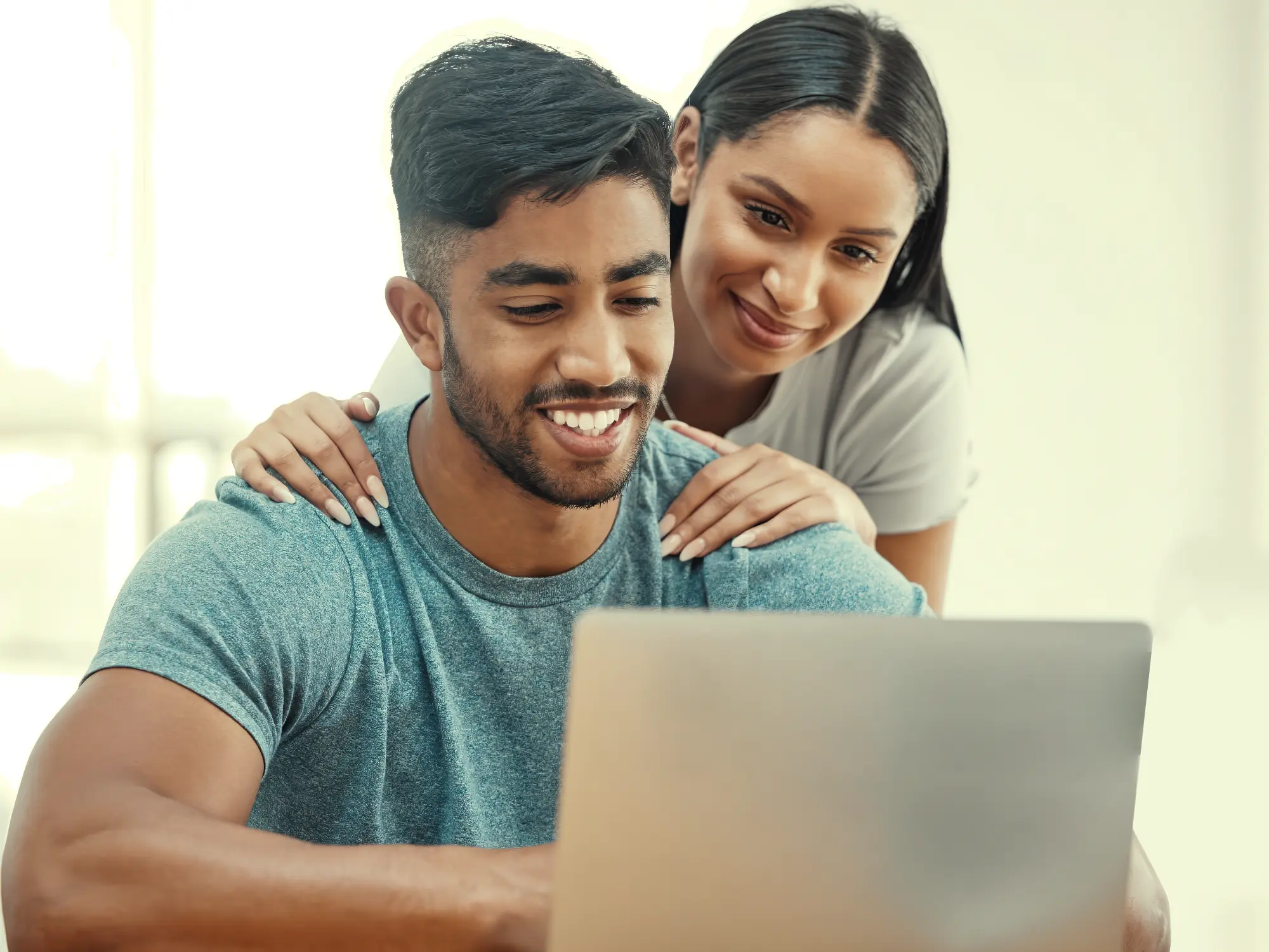 Young couple viewing laptop screen together
