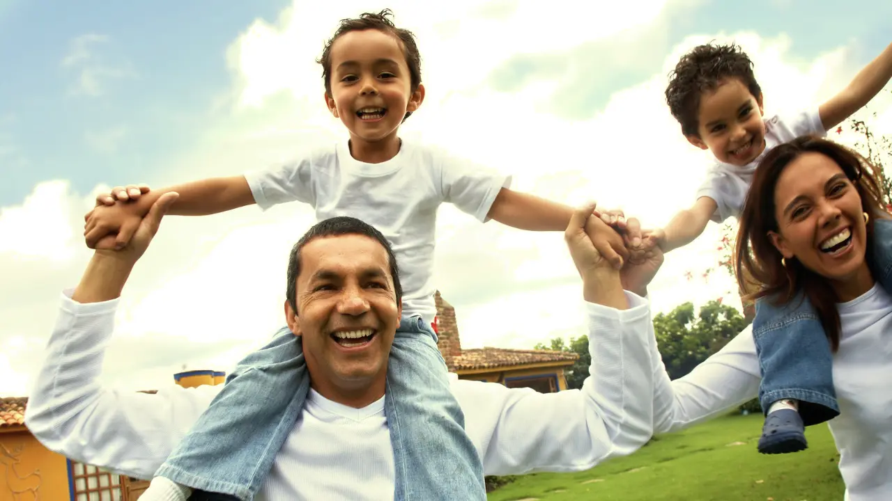 A happy Latino family outside playing