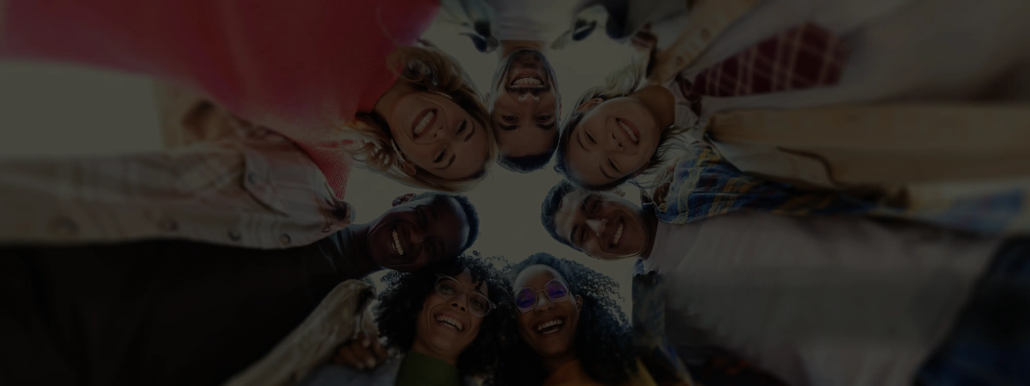 A multicultural group hugging in a circle