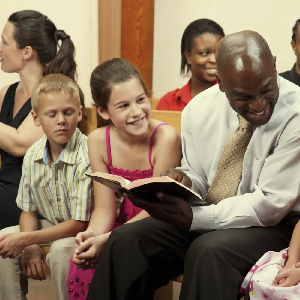 Adult church member sharing bible scripture with children